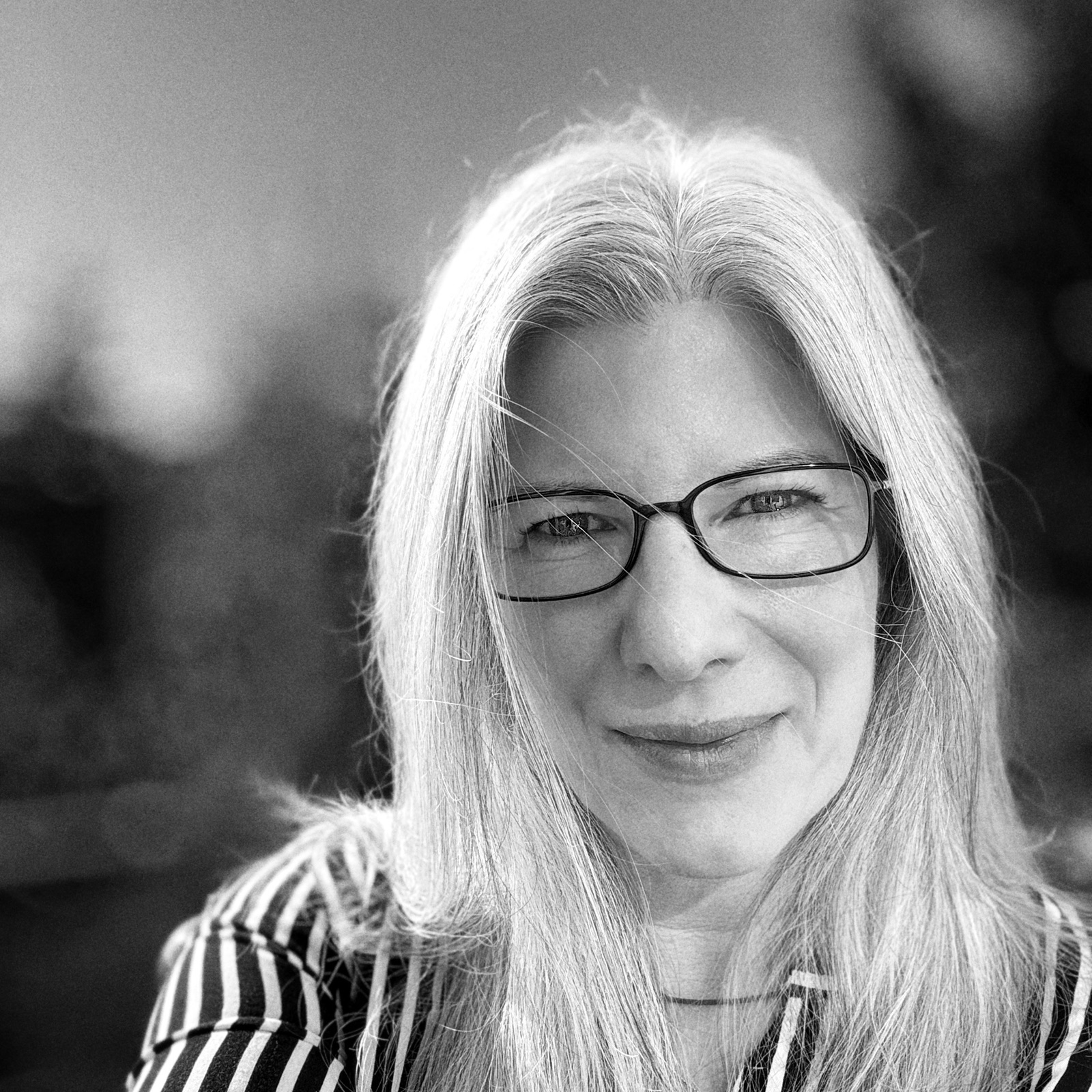 Black-and-white portrait of Emese Pogácsás wearing glasses
